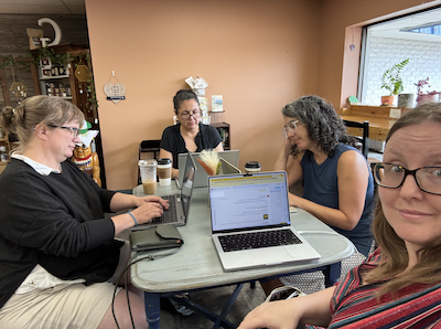 Four women working on computers at a coffee shop